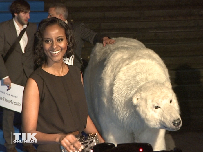 Ein wenig ratlos lacht Topmodel Sara Nuru, als ein lebensgroßer Plüsch-Eisbär als Teil einer Protestaktion für den Schutz der Arktis bei der Cinema for Peace Gala 2015 über den roten Teppich trottet.