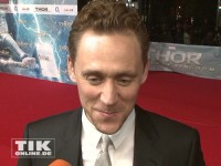 Tom Hiddleston lächelt verschmitzt bei der "Thor - The Dark Kingdom"-Premiere in Berlin