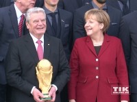 Joachim Gauck und Angela Merkel strahlen mit dem WM-Pokal