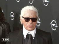 Karl Lagerfeld wie man ihn kennt: Zupf, Sonnenbrille, hochgeschlossenes weißes Hemd und schwarzer Anzug