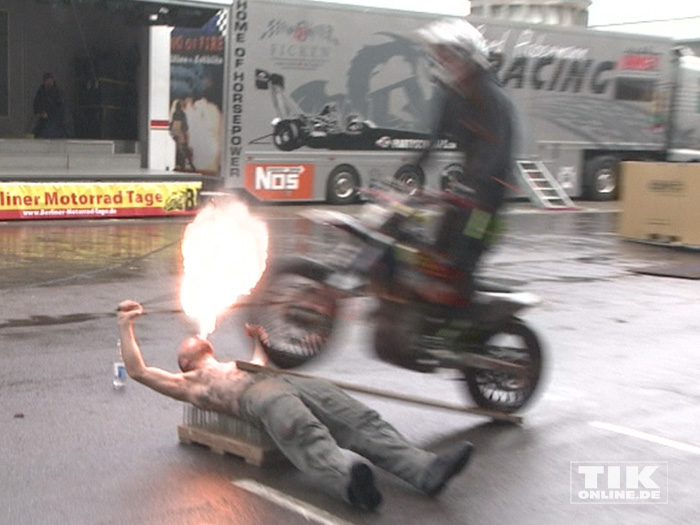 Stuntman Sebastian „Satu“ Kopke liegt auf einem Nagelbrett, spuckt Feuer und lässt ein Bike über sich hinwegbrausen beim Warm up der Berliner Motorrad Tage BMT 2016