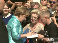 Kanzlerin Angela Merkel zeigte sich bei den Bayreuther Festspielen 2015 volksnah und schrieb Autogramme