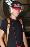 Justin Bieber mit cooler Cap, "Beats"-Kopfhörern und MCM Rucksack am Flughafen