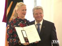 Zwinker: Eine sichtlich stolze Barbara Schöneberger posiert mit ihrem Bundesverdienstkreuz neben Bundespräsident Joachim Gauck
