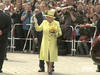 In Begleitung von Berlins Regierendem Bürgermeister Michael Müller winkt Queen Elizabeth II. der wartenden Menge vor dem Berliner Hotel Adlon zu