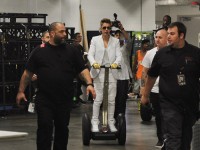 Justin Bieber in weißem Anzug und goldenen Handschuhen auf einem Segway