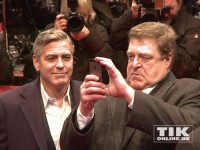 John Goodman macht unter den wachsamen Augen von George Clooney auf der Berlinale-Premiere von "Monuments Men" Erinnerungsfotos mit seinem iPhone