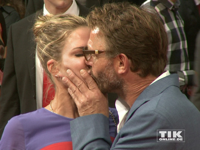 Thomas Kretschmann küsst seine Freundin Brittany Rice zärtlich auf dem roten Teppich der Premiere von "Hitman: Agent 47" in Berlin