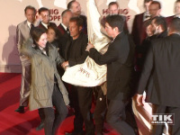 Til Schweiger mitten zwischen Sicherheitspersonal, Demonstranten und Transparenten bei der "Honig im Kopf"-Premiere