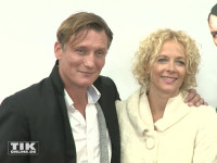 Hauptdarsteller Oliver Masucci und Katja Riemann posieren Arm in Arm auf der Premiere von "Er ist wieder da" in Berlin